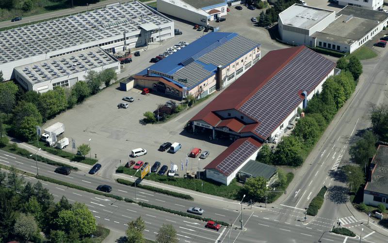 Luftbild des Betriebsgeländes in der Gottlieb-Daimler-Straße mit Parkflächen und Photovoltaikdach